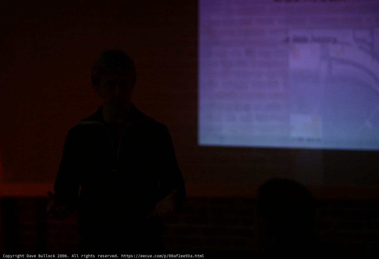 Man presenting in front of a projection screen