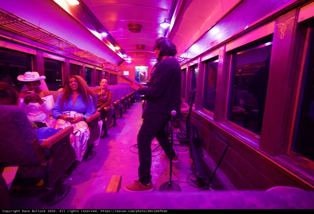 Live Music Performance in Vibrant Purple-Lit Train Car