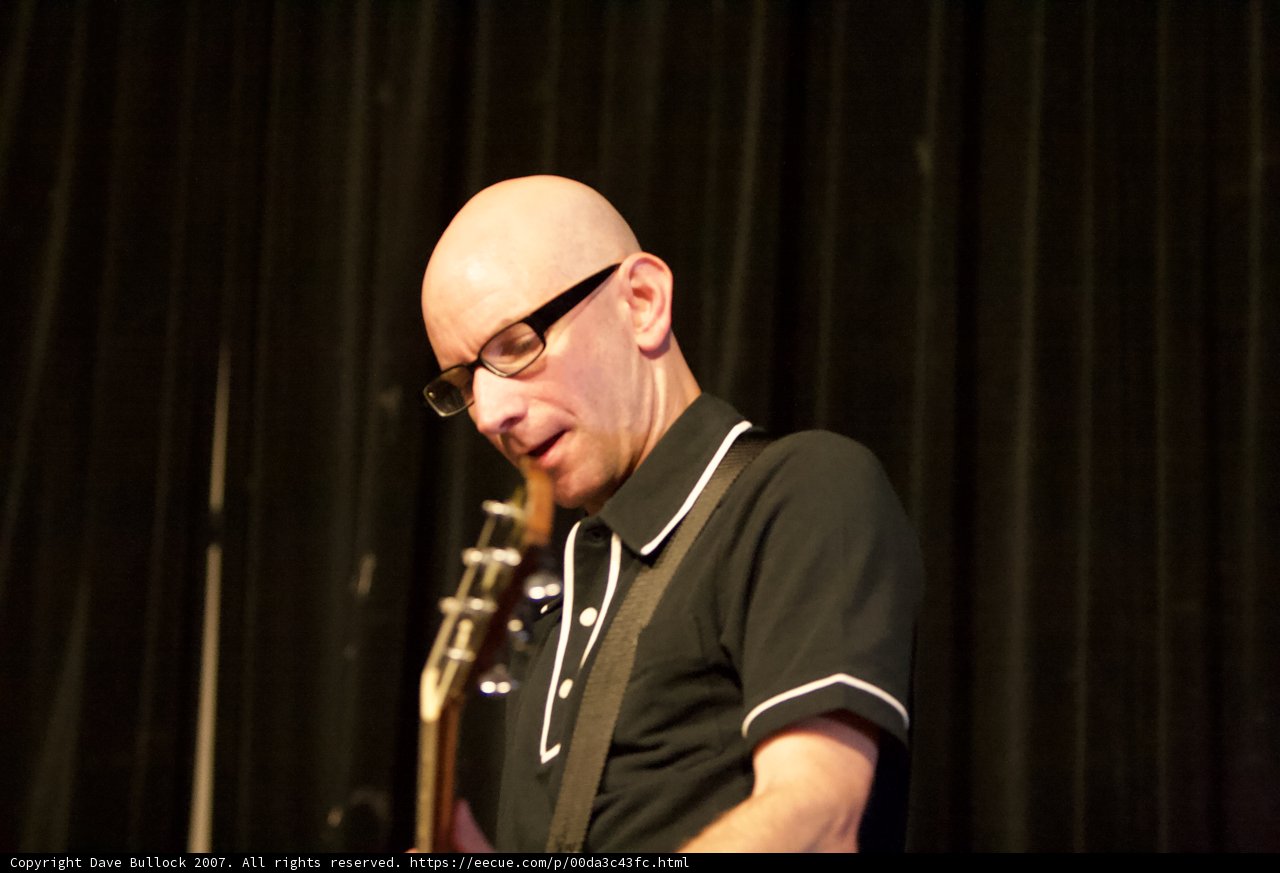 Bald Man with Glasses Strums a Tune