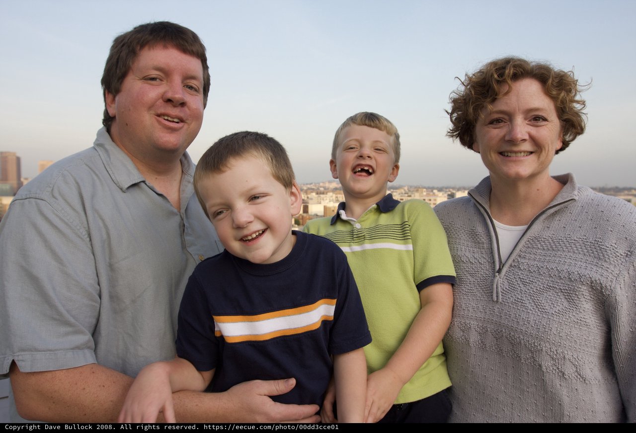 Happy Family Portrait on City Rooftop at Dusk