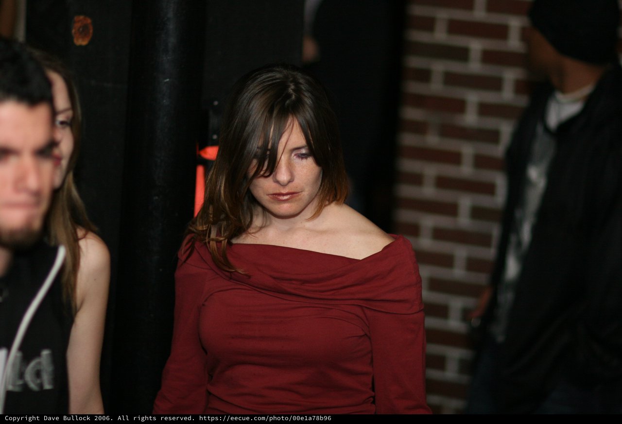 Contemplative Woman in Red at Dimly Lit Venue