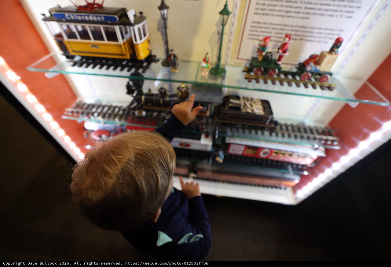 Child Exploring Miniature Train Display at Museum