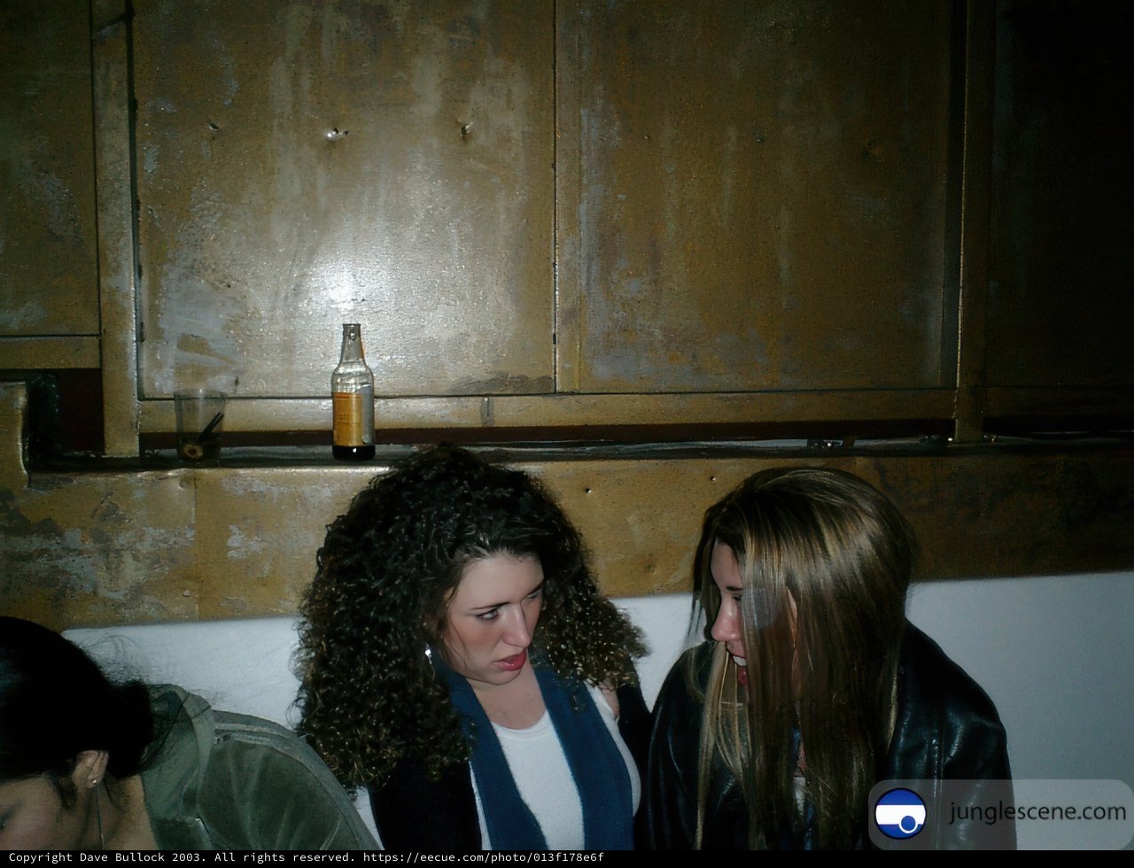 Two women enjoying a drink in a dark room