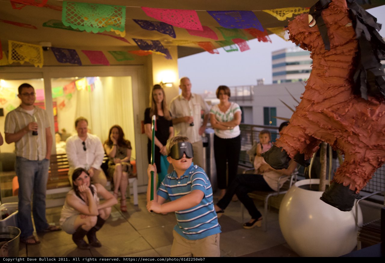 Blindfolded Boy Swings at Piñata at Rooftop Fiesta