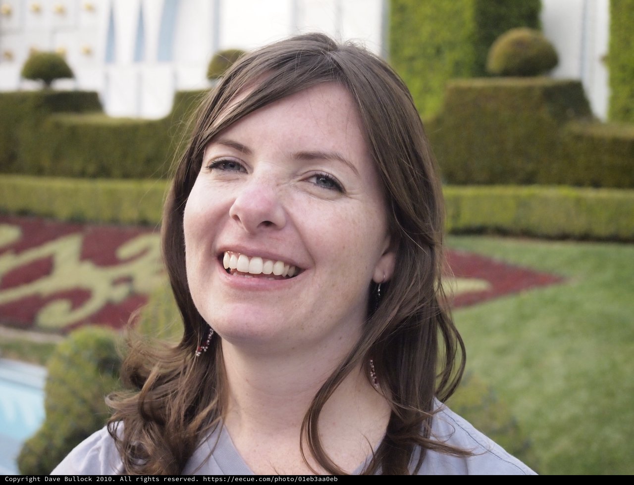 Joyful Woman Smiling at Formal Garden Grounds