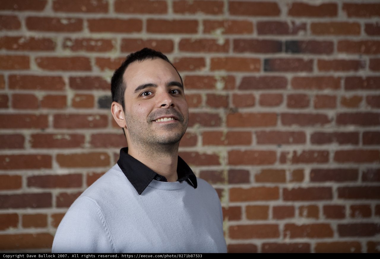 Happy Man Poses in front of Brick Wall