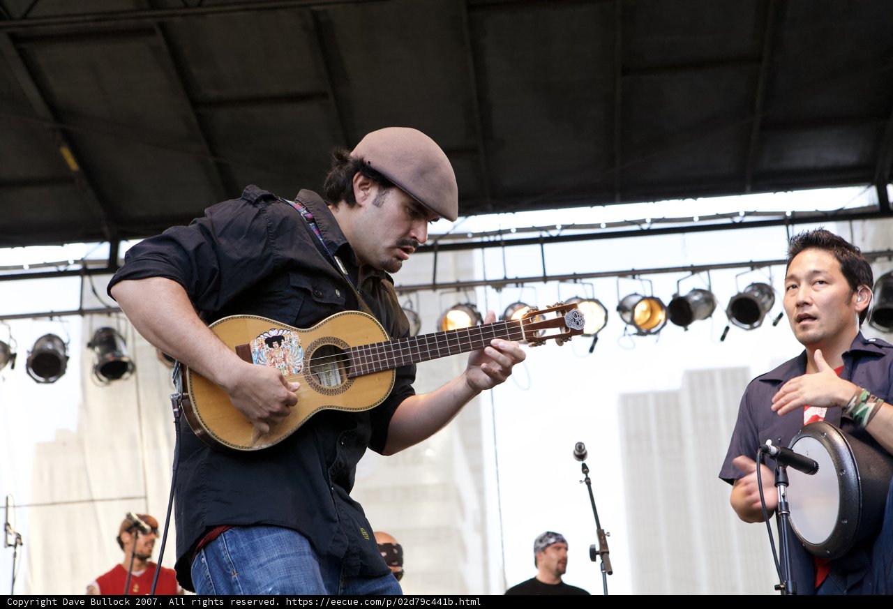 Takahiro Arai strums his guitar during Ozomatli's Grand Performance