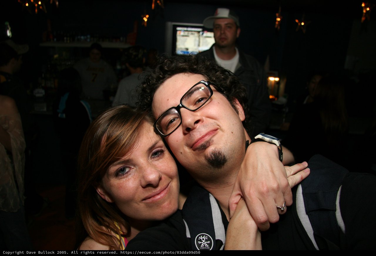 Friends Embrace at a Dimly Lit Bar Night