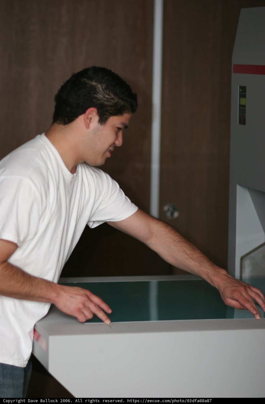 Man Standing in Front of Arcade Machine