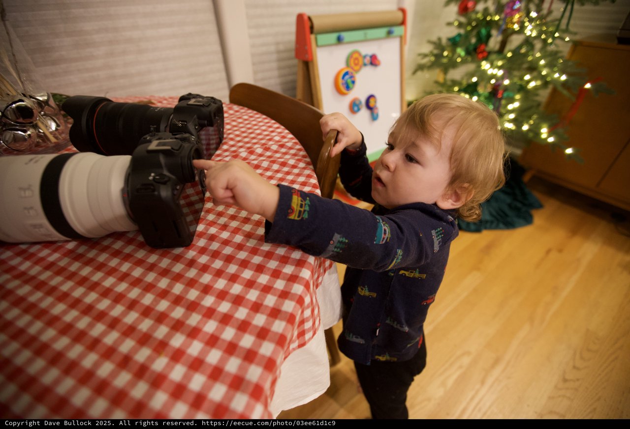 Young Child Exploring Professional Camera Equipment at Christmas