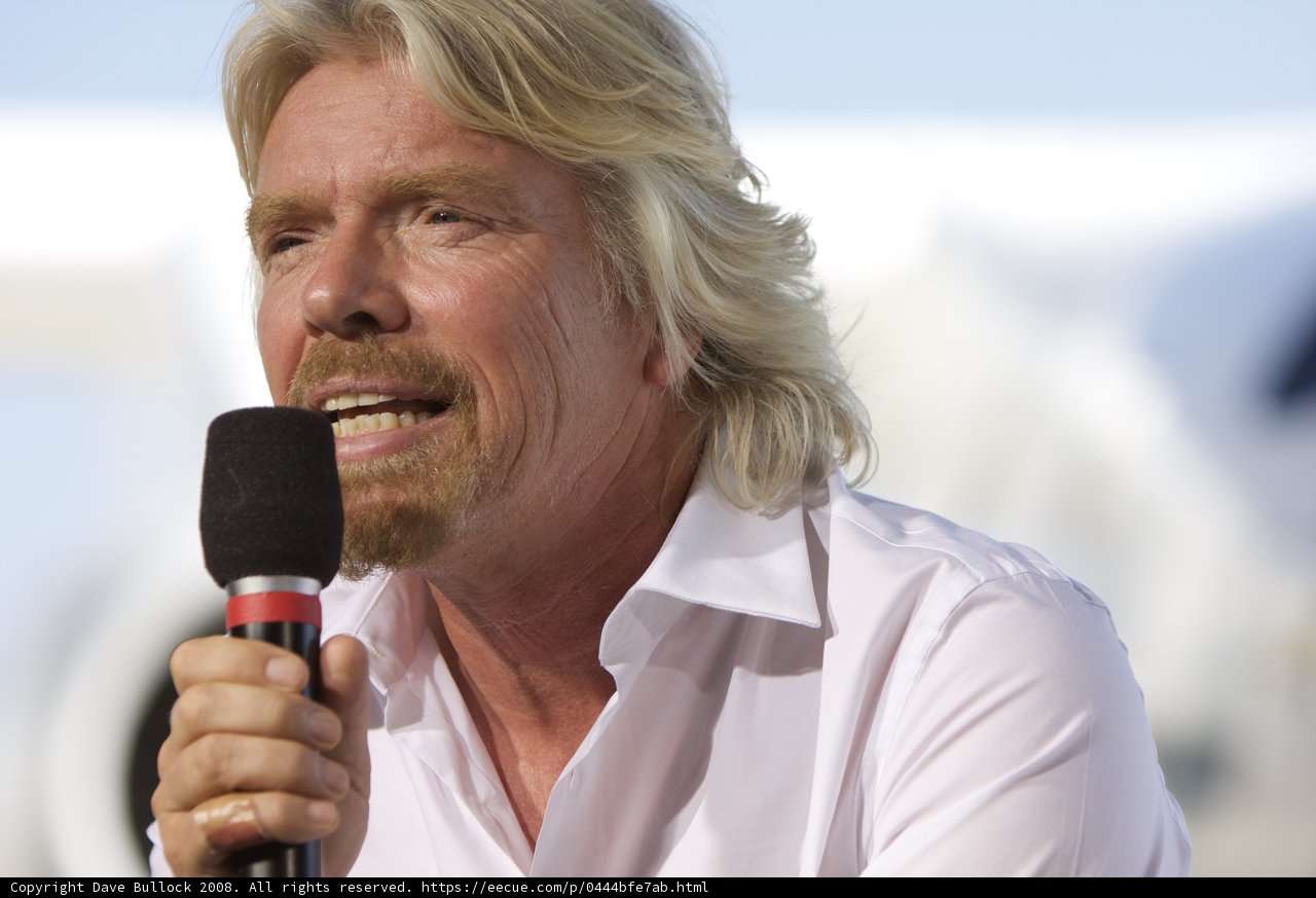 Richard Branson Addressing Crowd with Microphone
