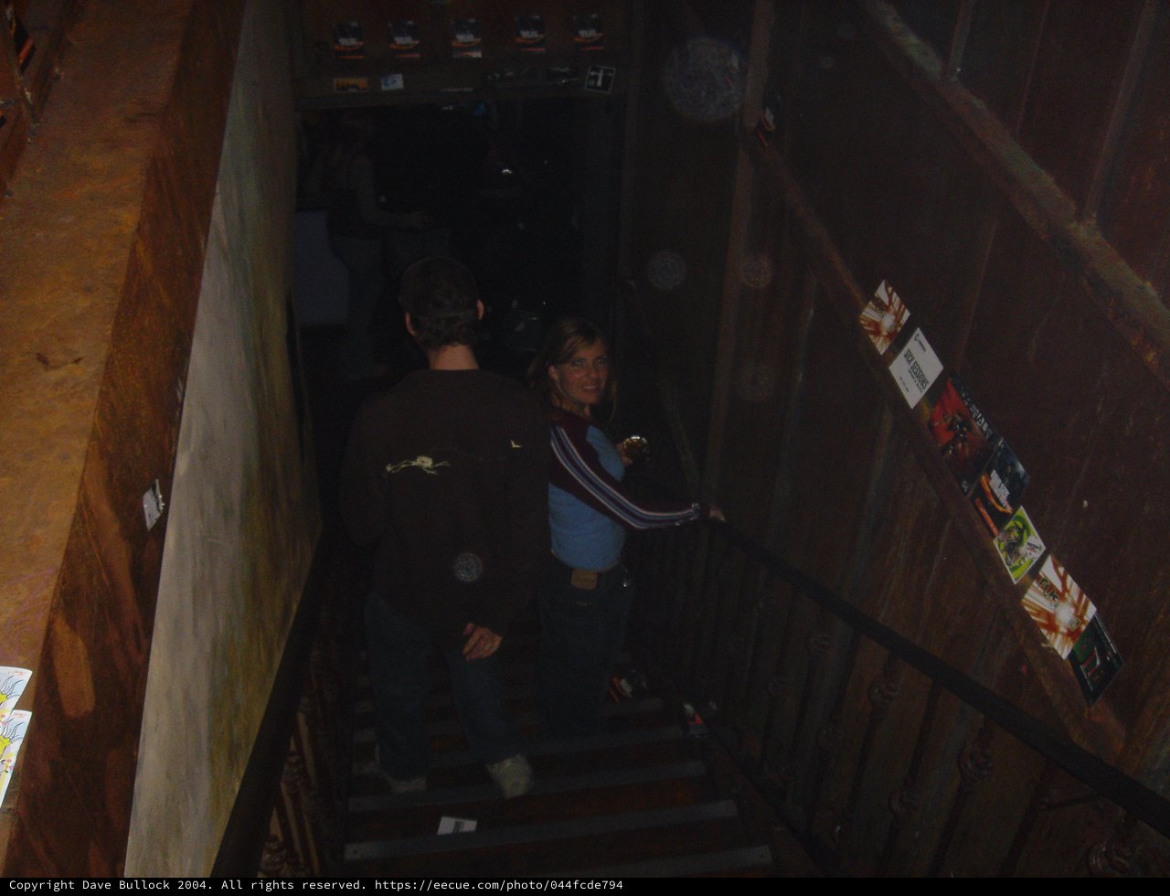 Friends Descending Dimly Lit Venue Staircase at Night