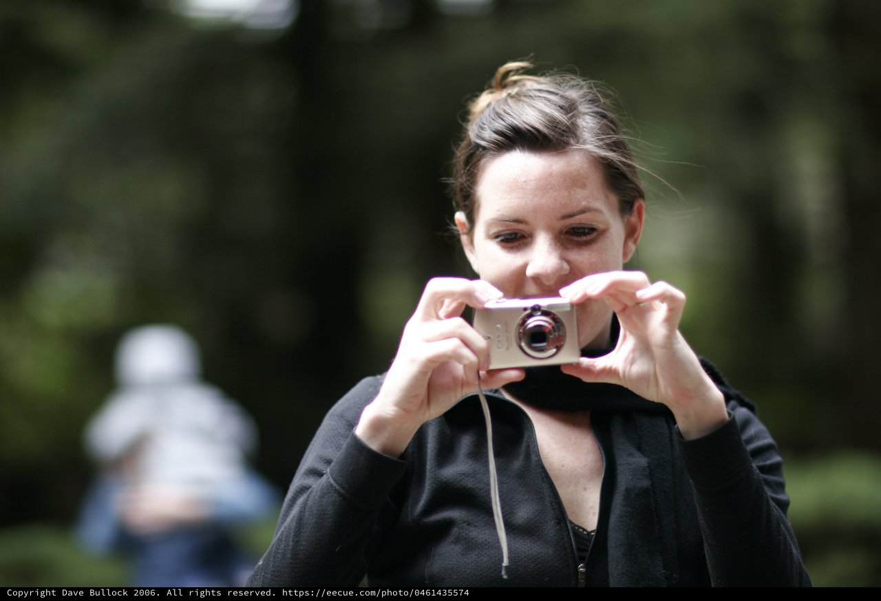 Woman Captures Memories with Compact Camera Outdoors