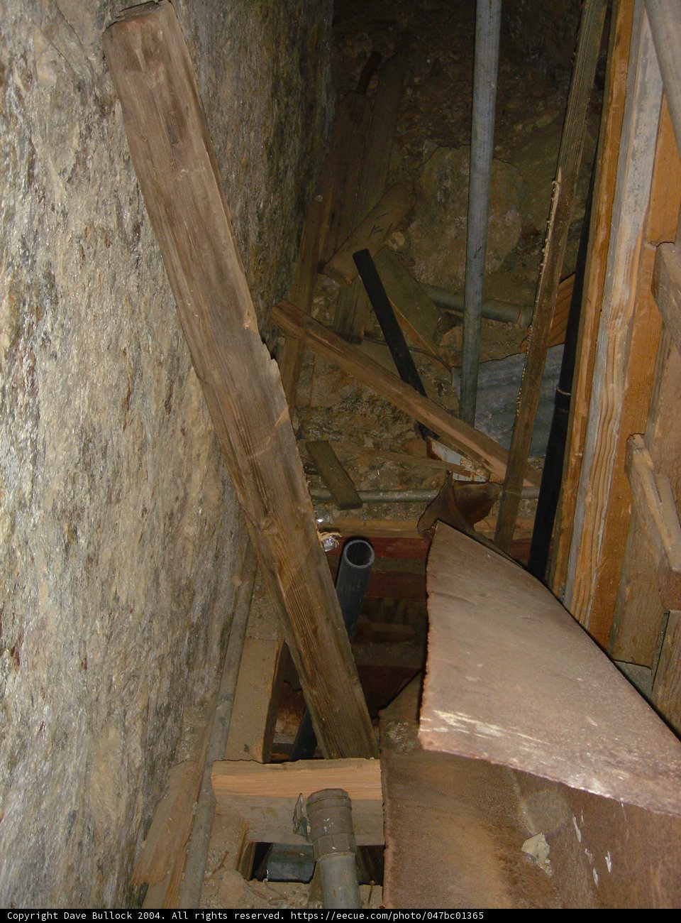 Leaning Plywood Beam in Dungeon-like Room