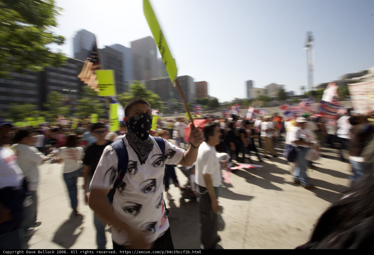 Mayday Protester Holds Flag and Mask