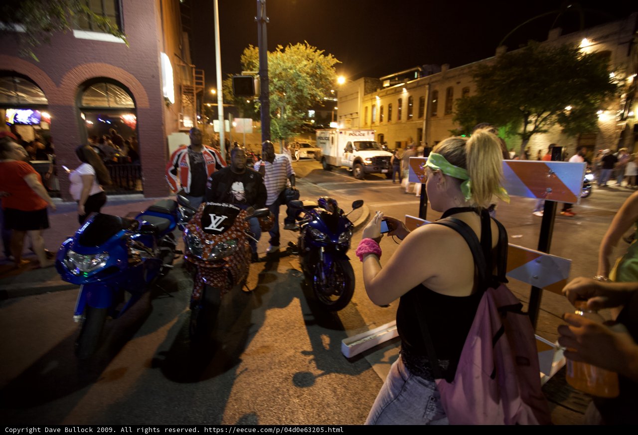 Woman poses with motorcycle at night