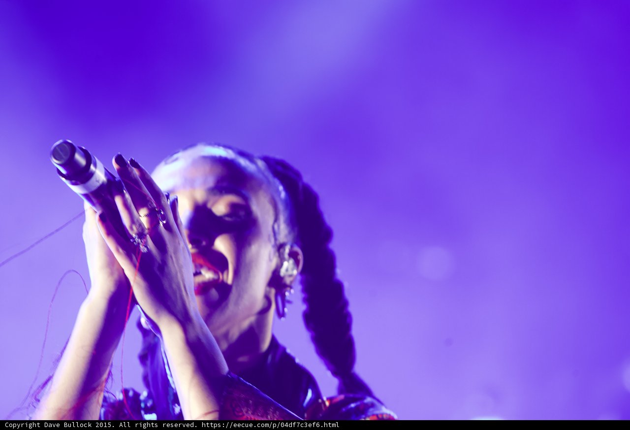 FKA twigs Emotional Portrait Eyes Closed Looking Up Baby Hairs Hoop Earrings Red Lipstick Braided Ponytails Both Hands Holding Microphone Rings Kimono Red Pattern Purple Blue Lighting