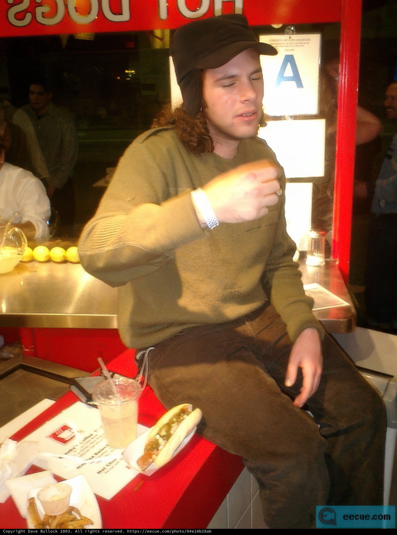 Man enjoying a hot dog at the restaurant