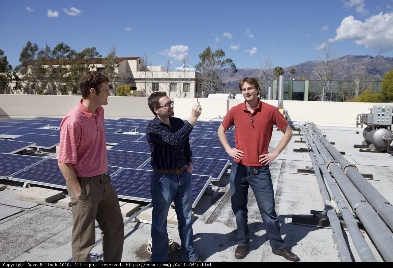 Three Men Installing Solar Panels on a Rooftop