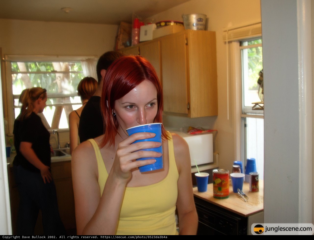 Red-haired woman enjoying a beverage in the kitchen
