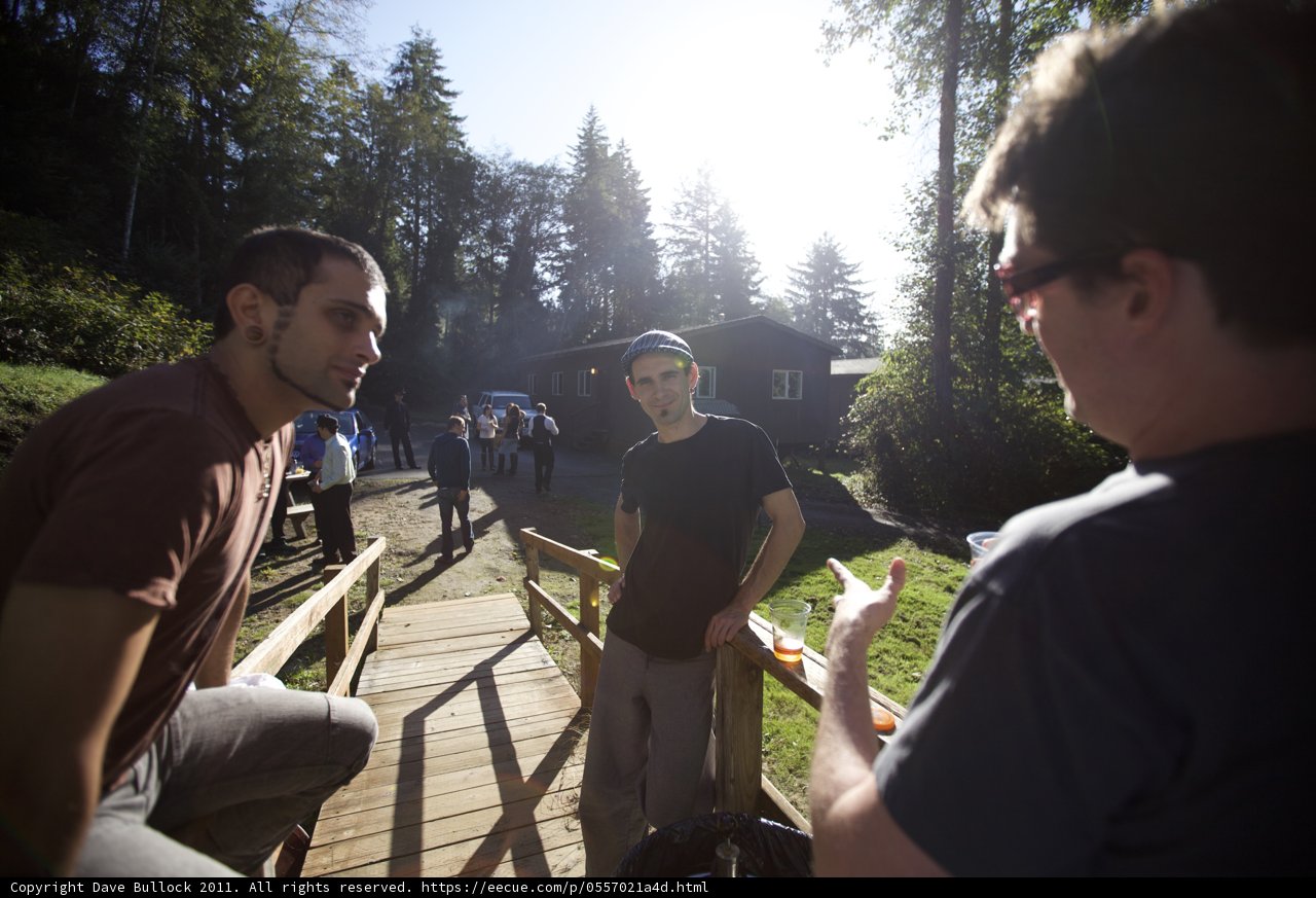 Three Men Chatting on Wooden Bridge