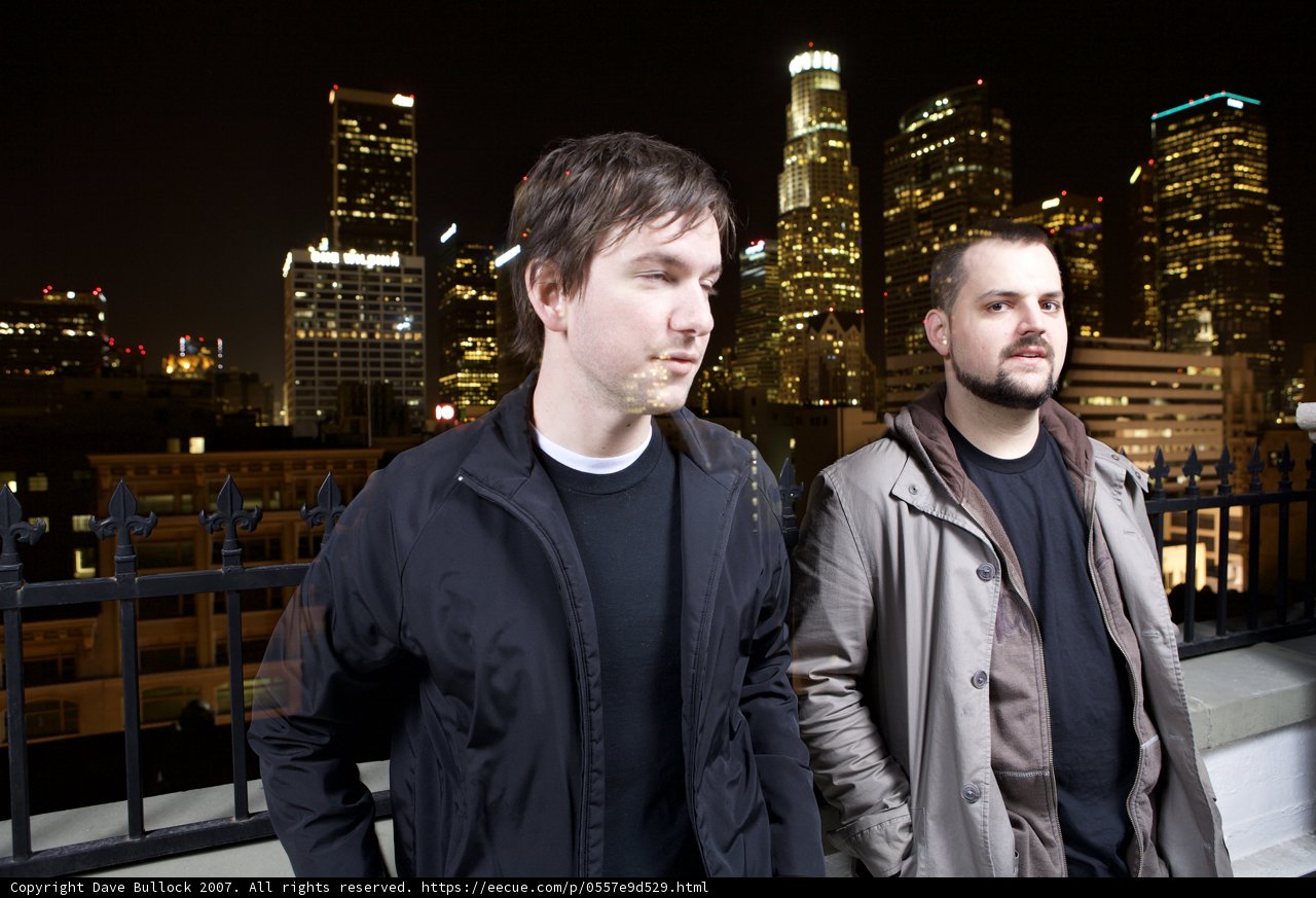 Two Men in Overcoats Standing Before the City