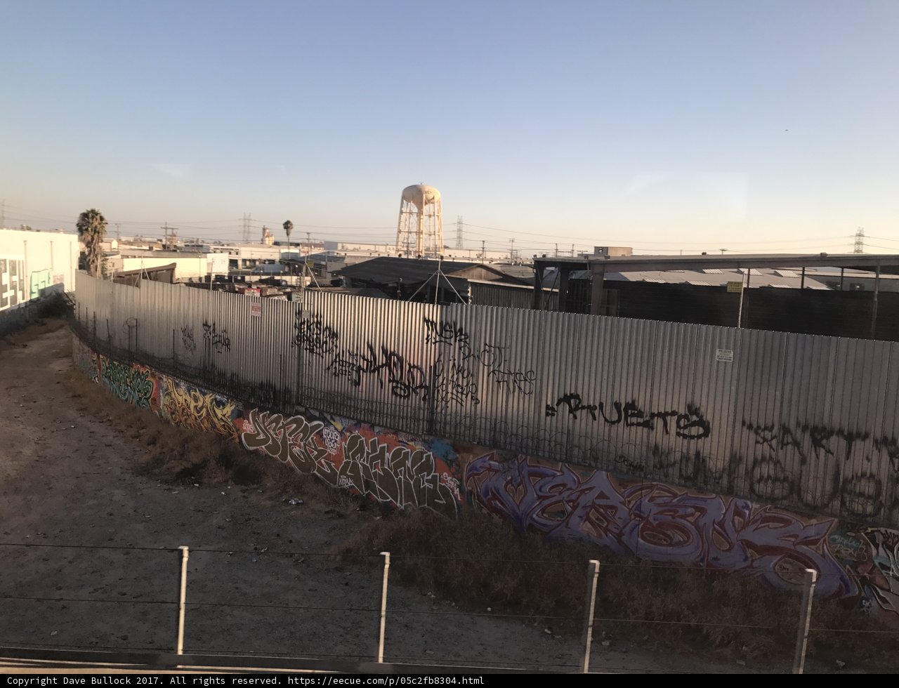 Graffiti on the Berlin Wall Memorial fence with a water tower in the background