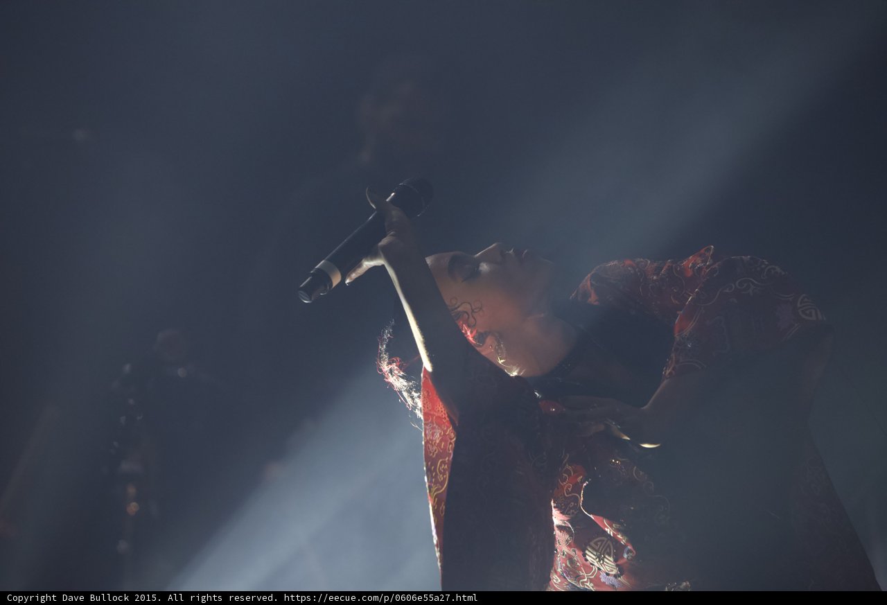 FKA twigs Dramatic Silhouette Microphone Raised Face Backlit Red Brocade Kimono White Light Beams