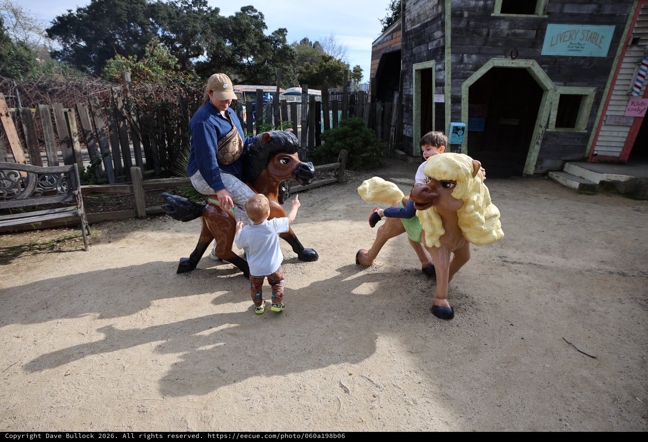 Children Playing with Vintage Carousel Horses at Theme Park