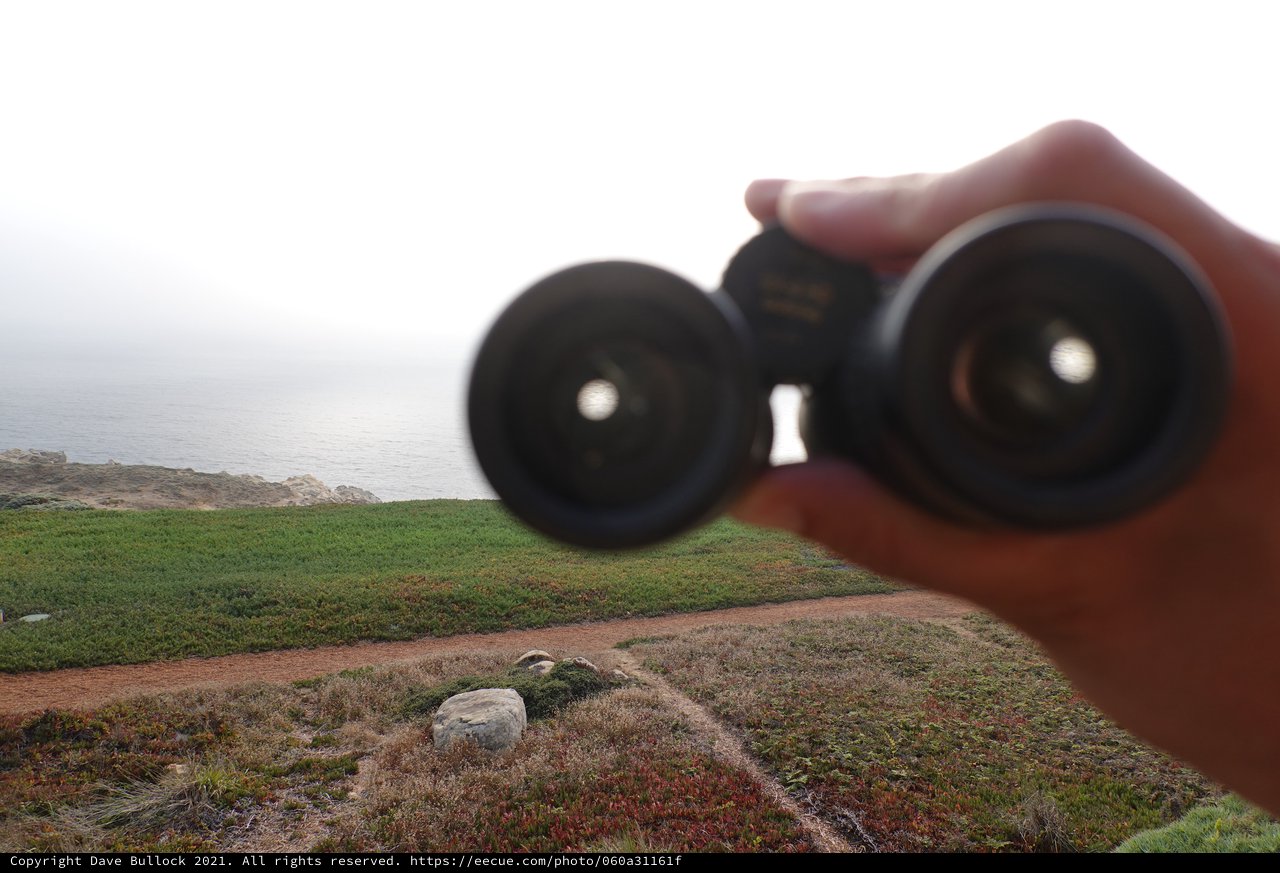 Binoculars Overlooking Misty Coastal Landscape