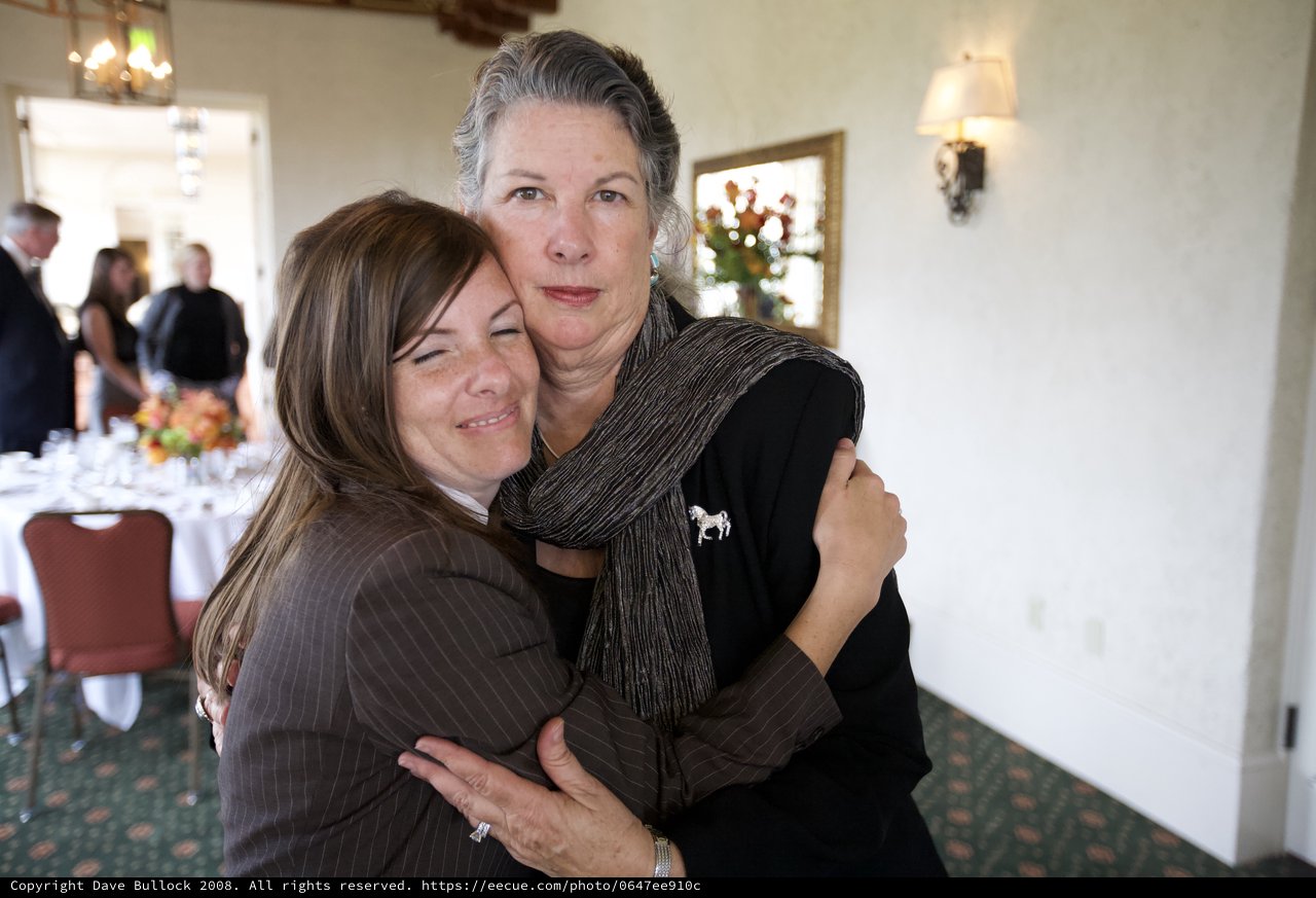 Two Women Share Emotional Embrace at Funeral Reception