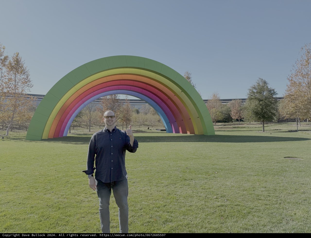 Man Posing with Giant Rainbow Art Installation