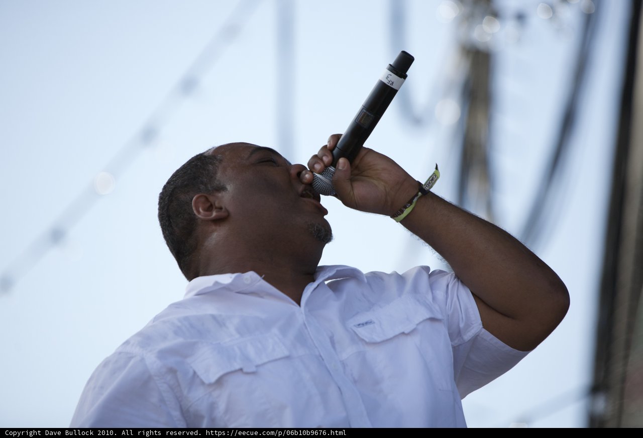 Man in White Shirt Belts Out an Electrifying Performance with a Microphone