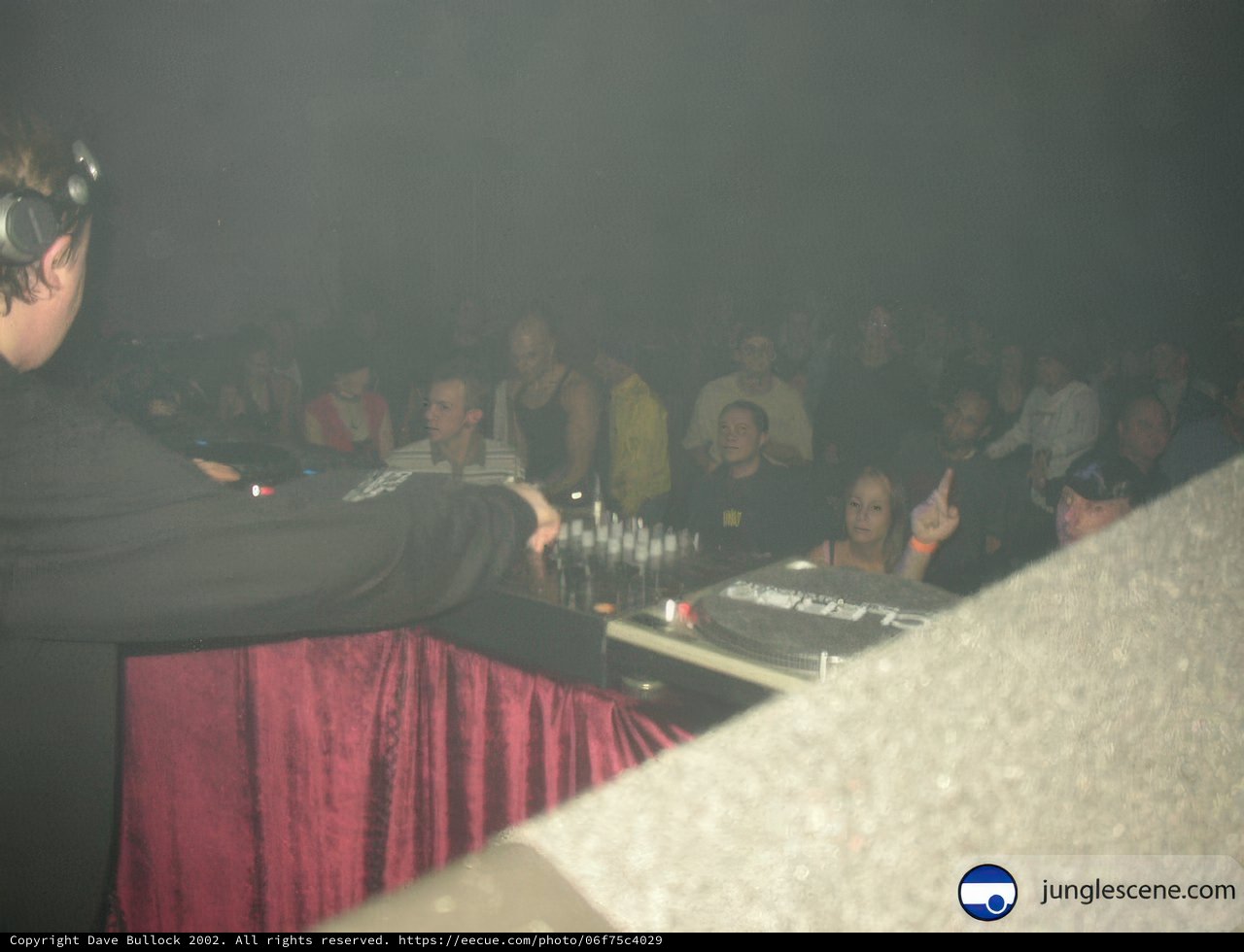 Nightclub DJ surrounded by enthusiastic crowd