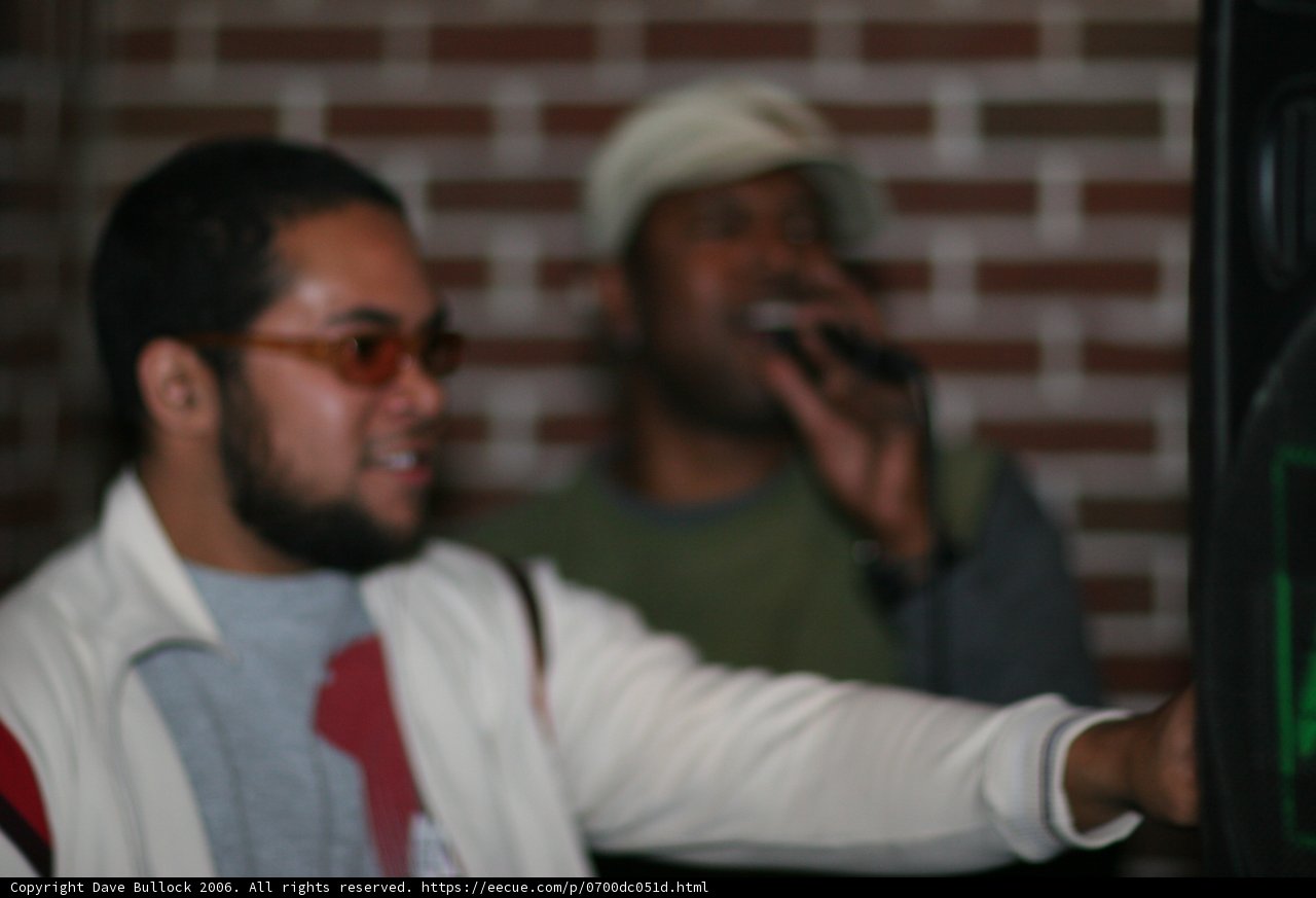 Steve J in White Jacket and Glasses Holding Microphone
