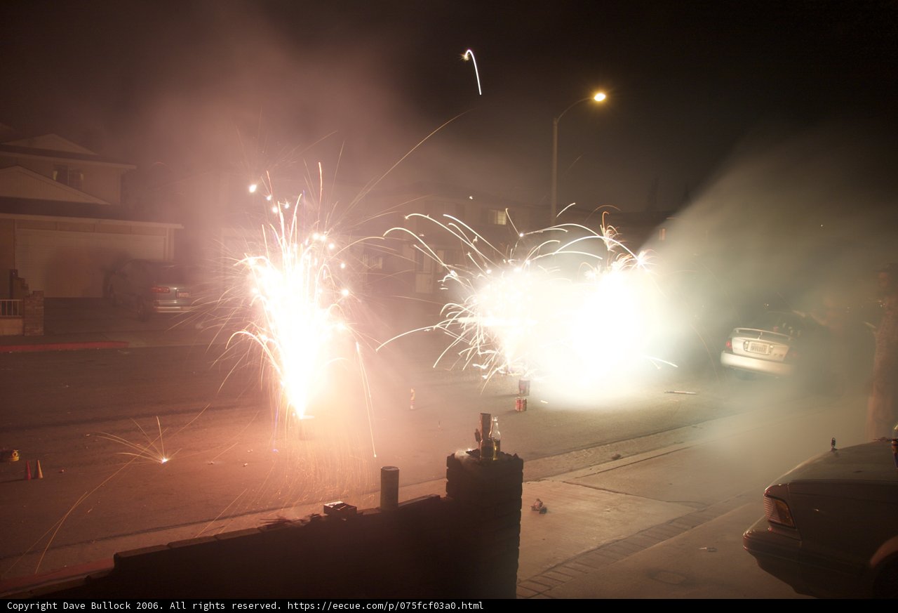 Fireworks Illuminate the Night Sky over a Busy Street
