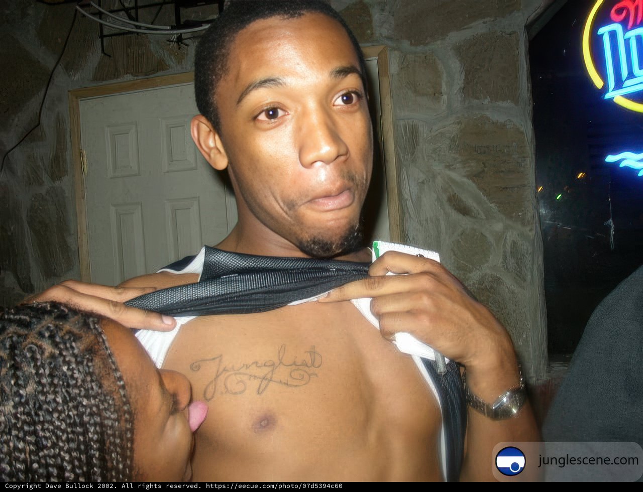 Tattooed Man Adjusting His Shirt