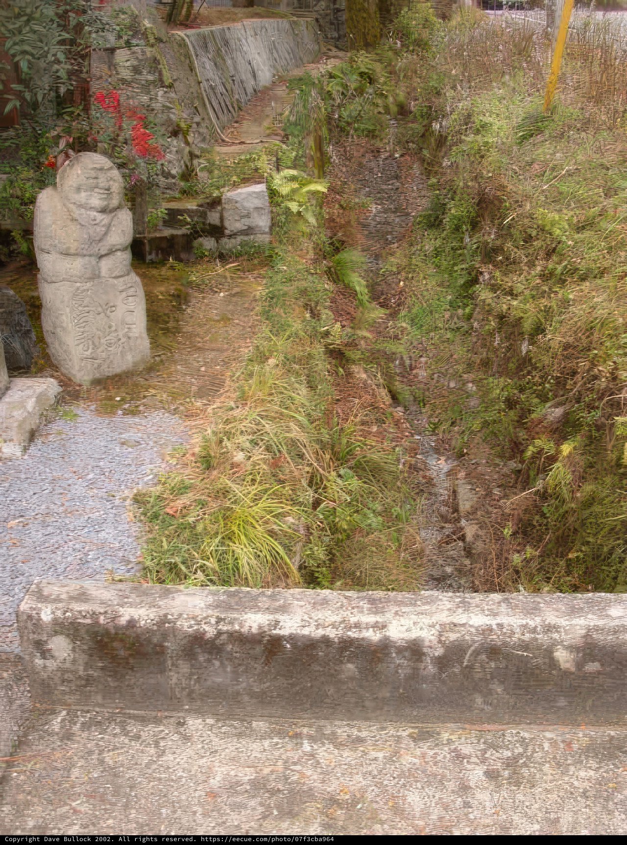 Serene Stream with Stone Statue