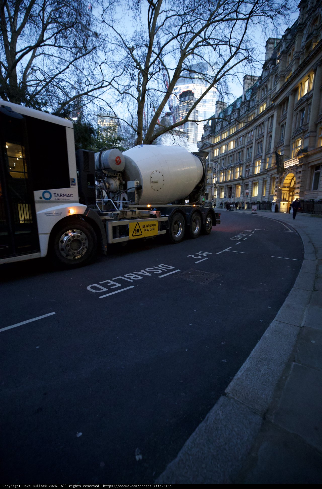 Concrete Mixer Truck Navigating Curved London Street at Dusk