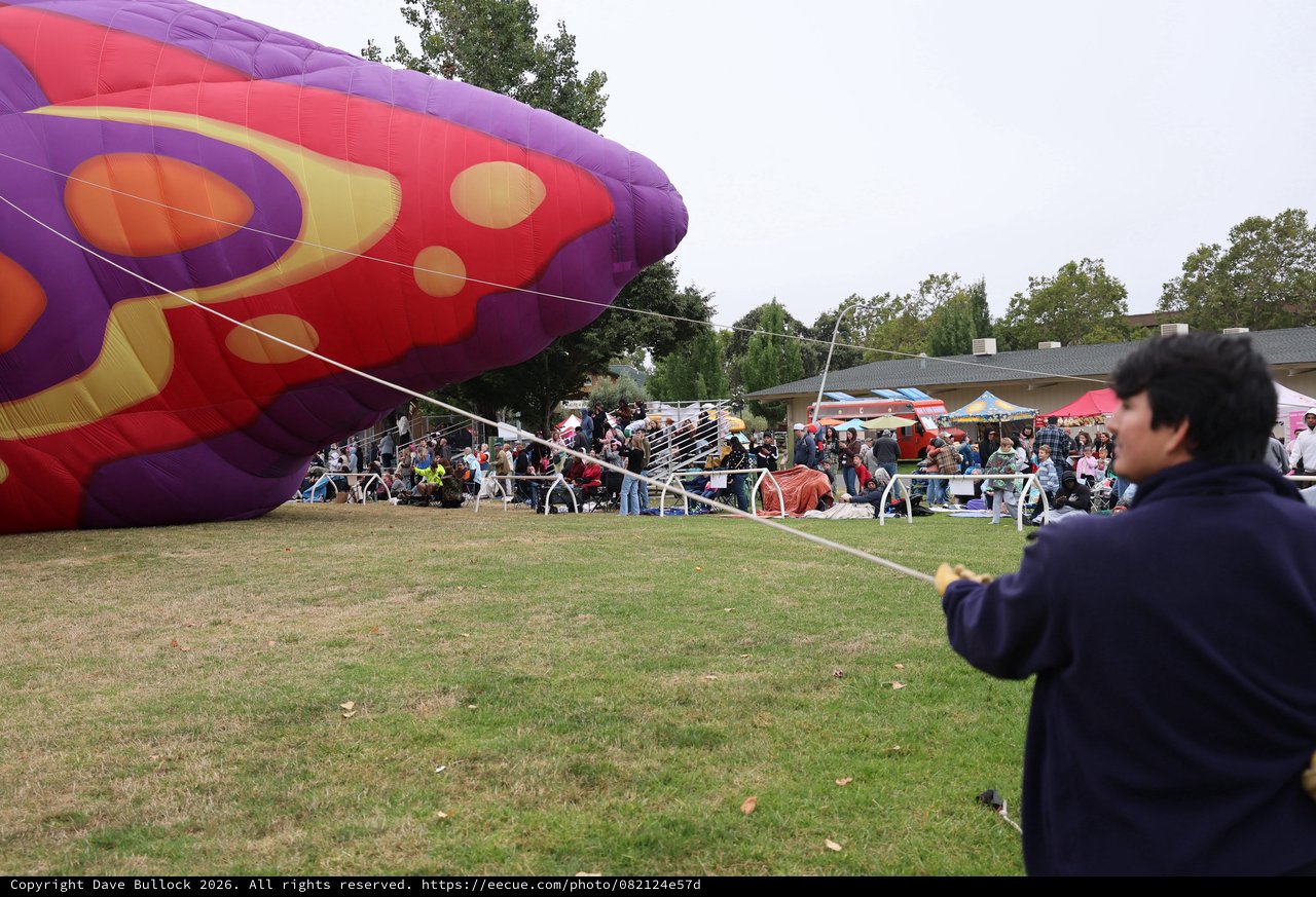 Ground Crew Tethers Colorful Hot Air Balloon at Festival