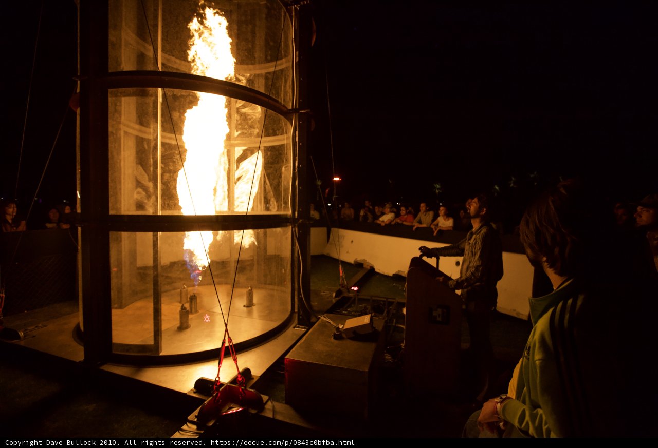 Man stands in front of fiery display