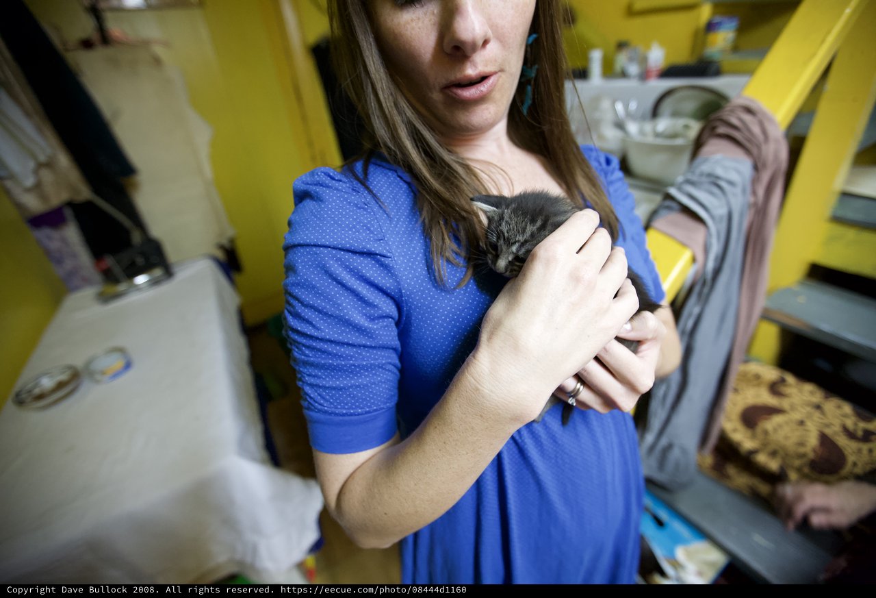 Woman Tenderly Cradling a Tiny Newborn Kitten