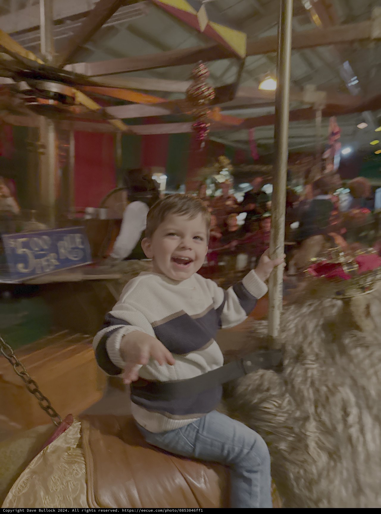 Joyful Child Riding Carousel at Amusement Park