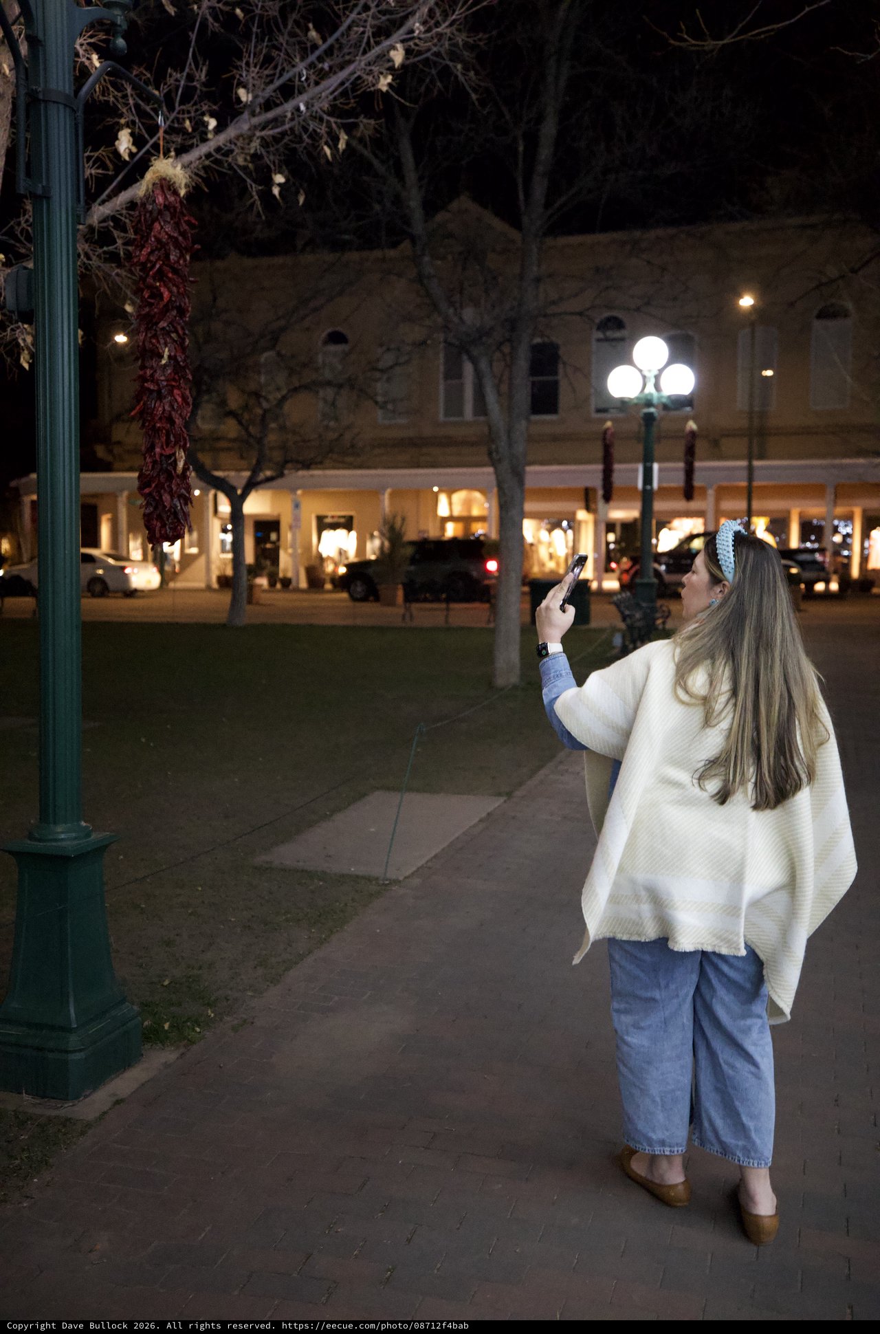 Woman Photographing Plaza Decorations at Night in Santa Fe