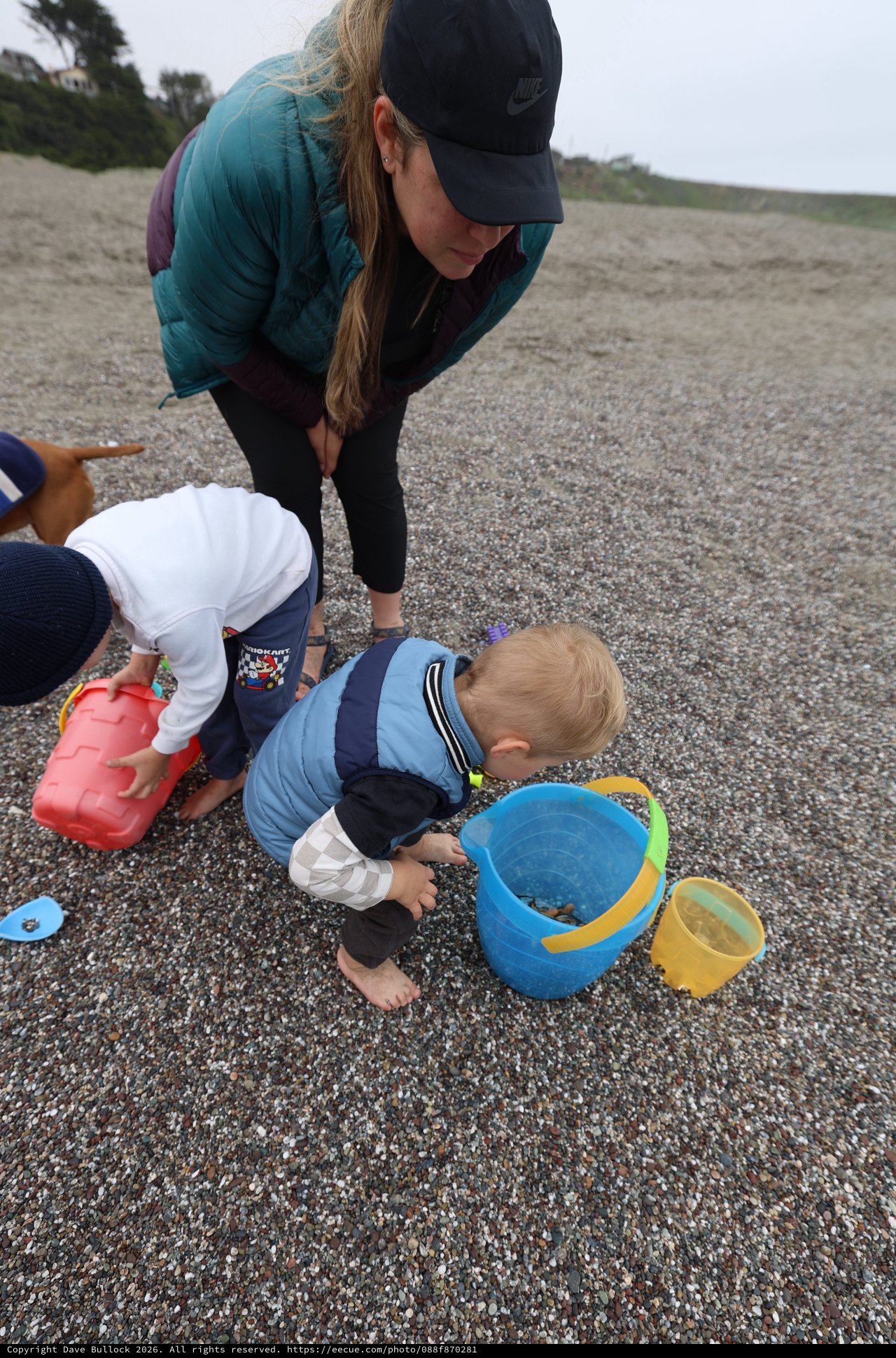 Toddlers Exploring Pebbles on a Misty Beach
