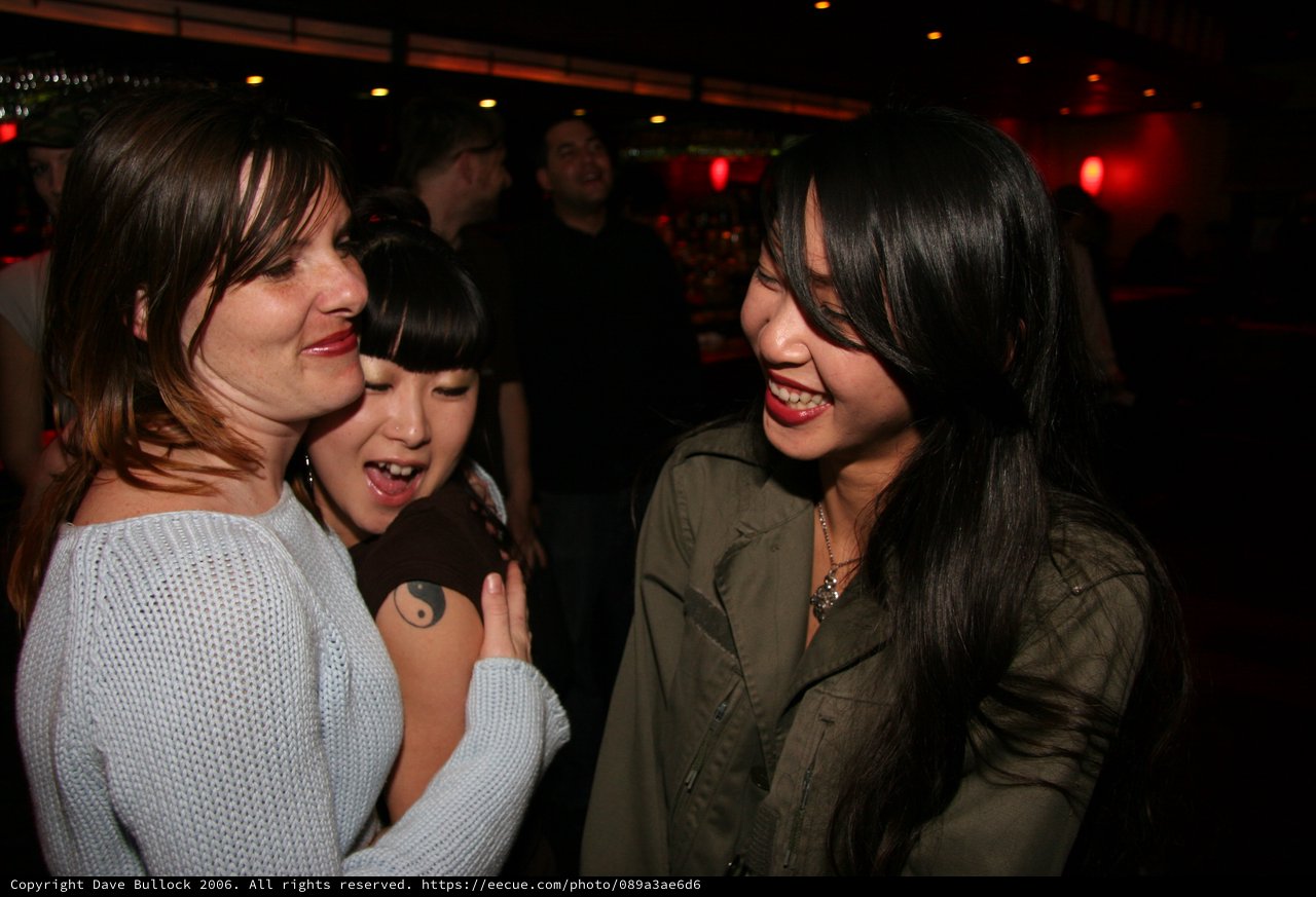 Three Friends Laughing Together at a Nightclub
