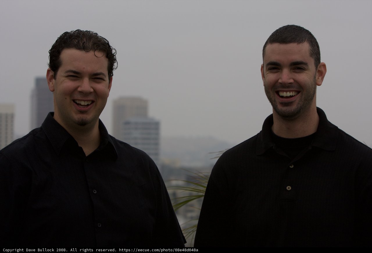 Two Happy Men in Black Shirts Laughing Outdoors
