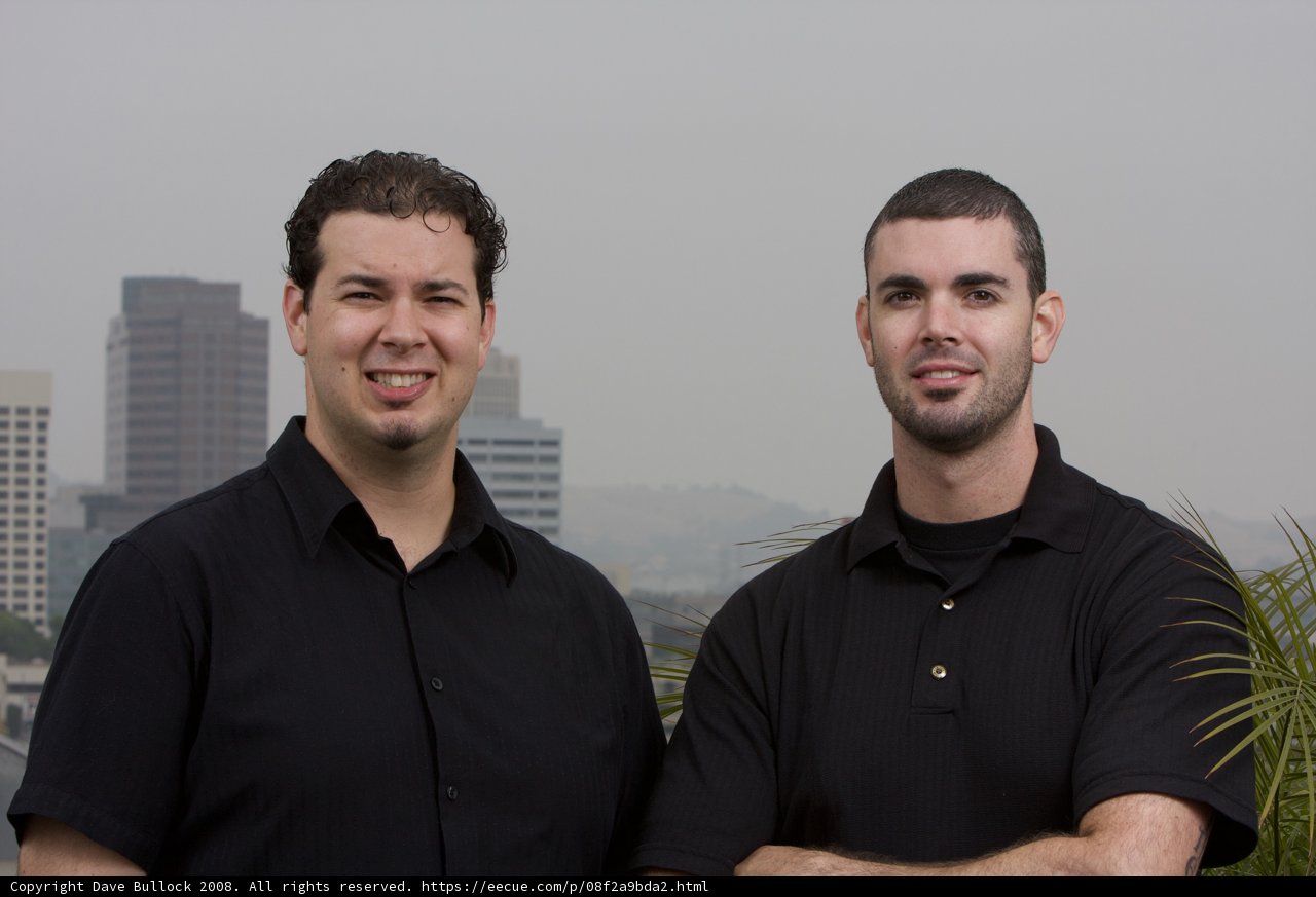 Two Men Posed with Skyscraper Building