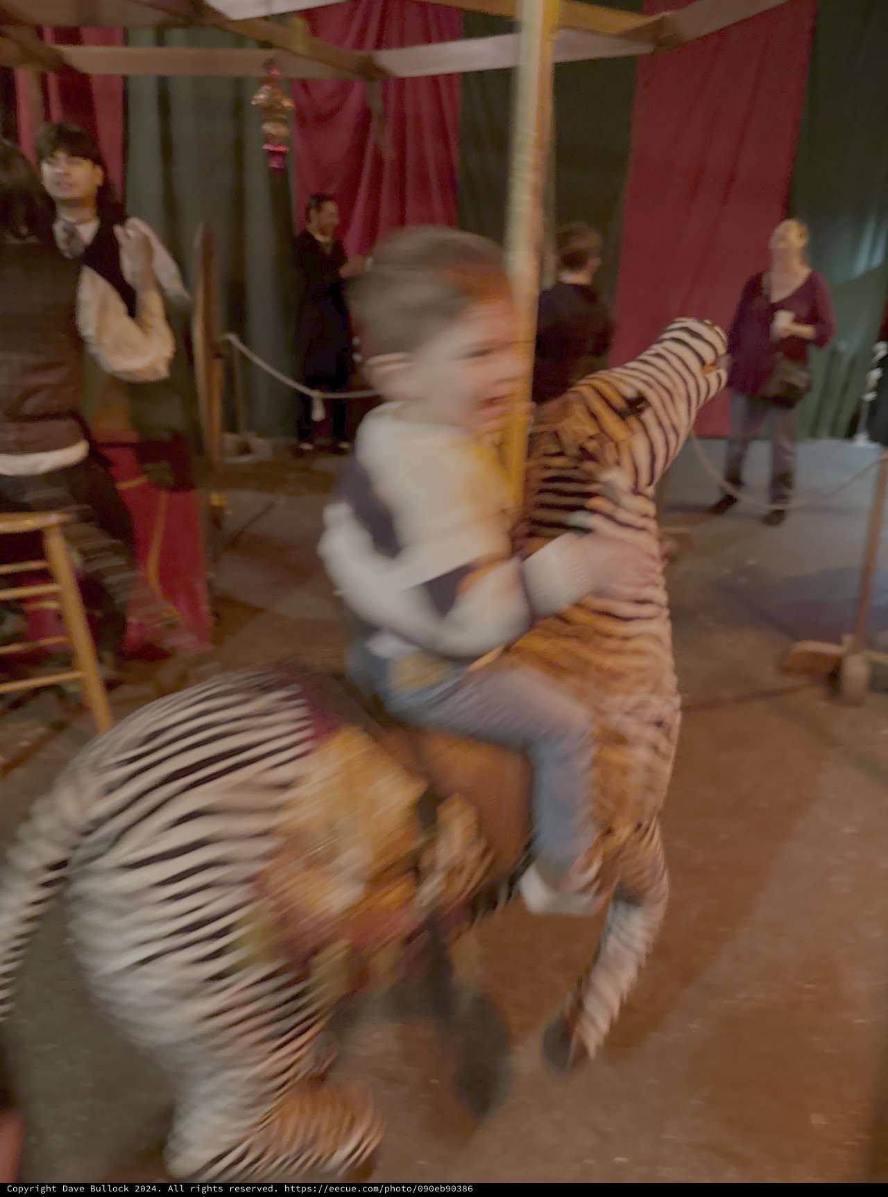 Child Riding Motion-Blurred Carousel Tiger