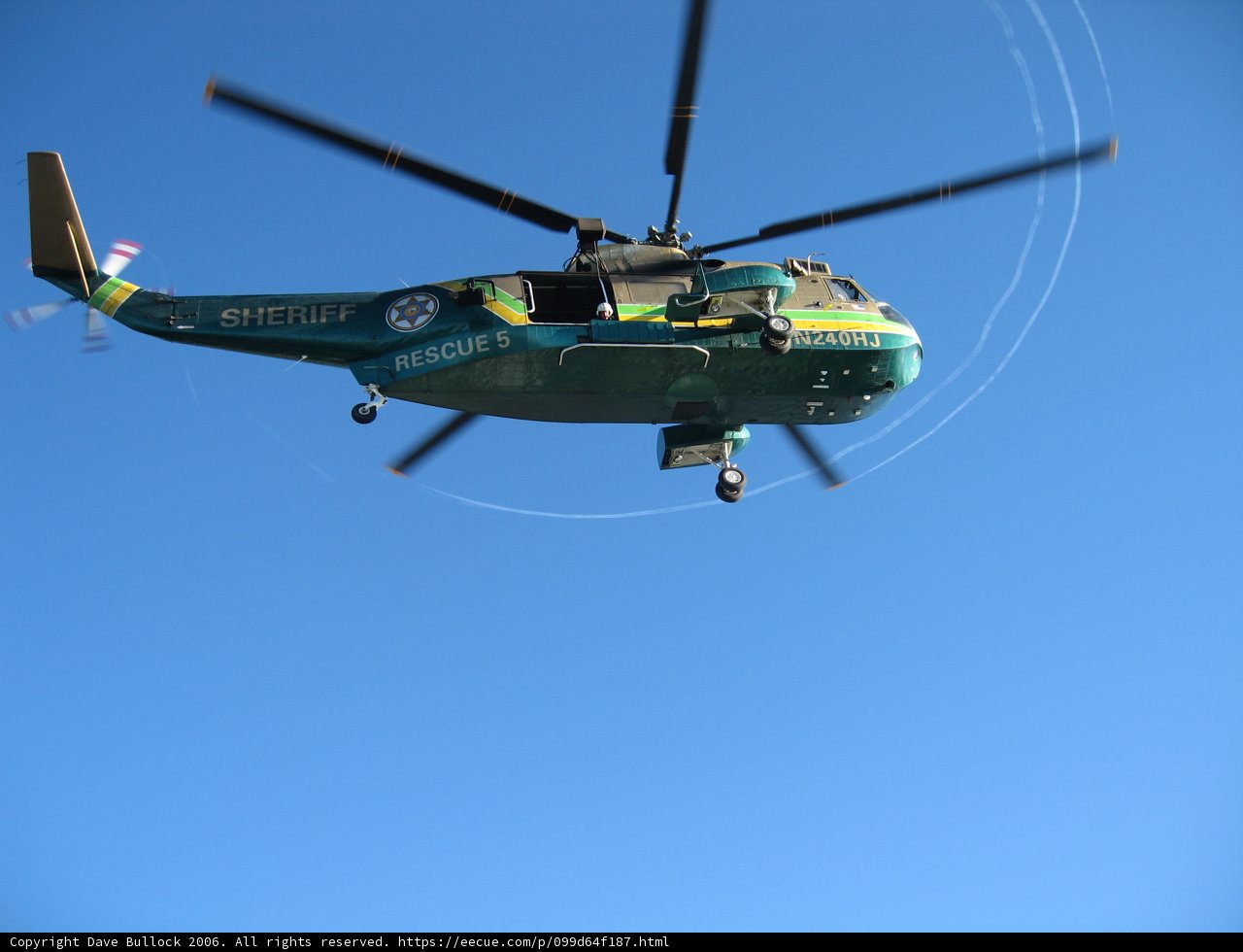 Green Helicopter Soaring High in the Blue Sky